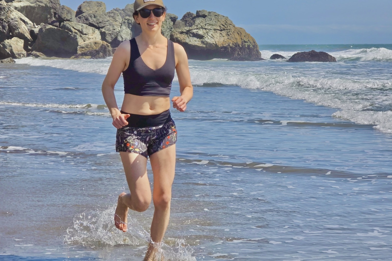 A woman runs on the beach in her Oiselle shorts.