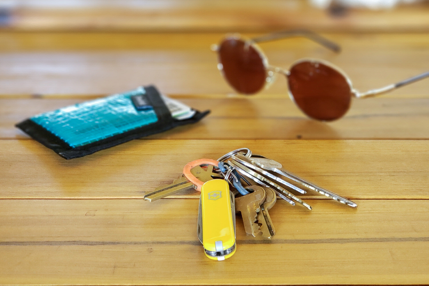 The Victorinox Swiss Army Classic SD keychain multitool with a wallet and sunglasses